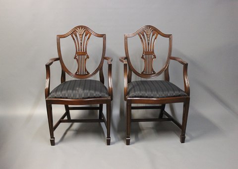Et par heppelwhite armstole i poleret mahogni og polstret i sort stof. Stolene 
er fra England og 1920erne. 
5000m2 udstilling.