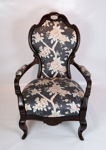 Antik armstol af poleret mahogni, polstret med blomstret stof og i flot stand 
fra 1860erne.
5000m2 udstilling.