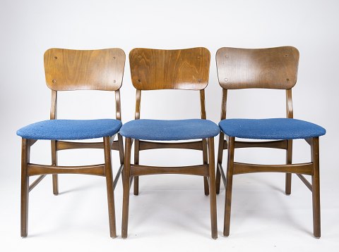 Sæt af tre 
spisestuestole af mørkt træ og blåt stof af dansk design 1960erne.
5000m2 udstilling.
