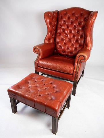 Engelsk lænestol med fodskammel i Chesterfield stil med dyb hæftede knapper, ben 
af mahogni fra det 20. århundrede.   
5000m2 udstilling.
