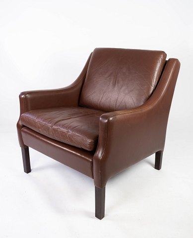 Lænestol polstret med mørke brunt læder og ben af mørkt træ, af dansk design fra 
1960erne. 
5000m2 udstilling.
