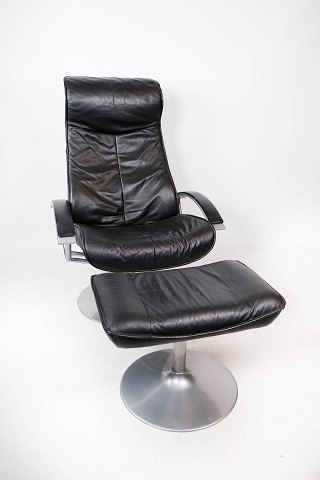 Easy chair with stool upholstered with black leather and frame of metal, of 
Danish design from the 1970s.
5000m2 showroom.